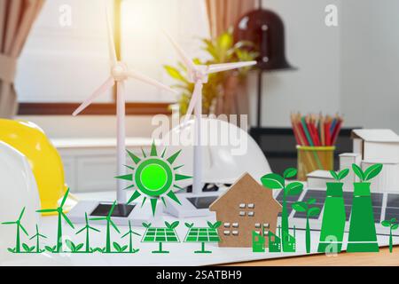 Engineer with wind turbine model sitting at desk in office, illustration of solar-powered house. Wind turbine model, construction plan and laptop on t Stock Photo