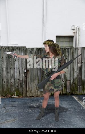 Beautiful young woman soldier with a pistol and rifle Stock Photo