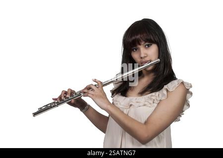 Beautiful young woman playing the musican instrument the flute Stock Photo