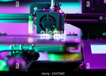 3d printer nozzle arm head printing layer project prototype pink light printing machine display Stock Photo