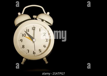 Close-up of a Vintage white alarm clock isolated on a black background and copy space Stock Photo