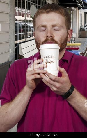 Young handsome man drinking a fresh cup of coffee Stock Photo