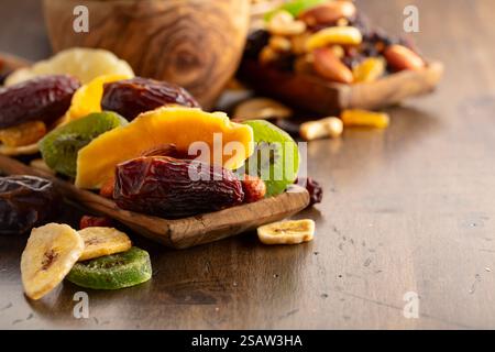 Dried tropical fruits with various nuts and raisins on a old wooden table. Stock Photo