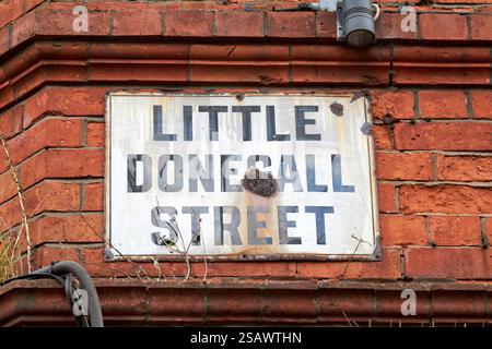 old rusting street sign on red brick wall little donegall street belfast, northern ireland, uk Stock Photo