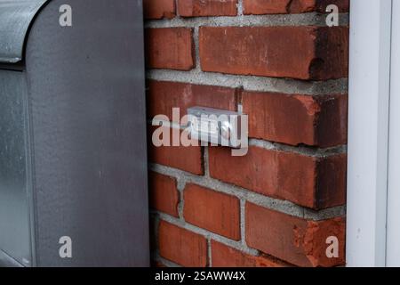 Close up of a simple house doorbell on a bricks wall near the front door Stock Photo