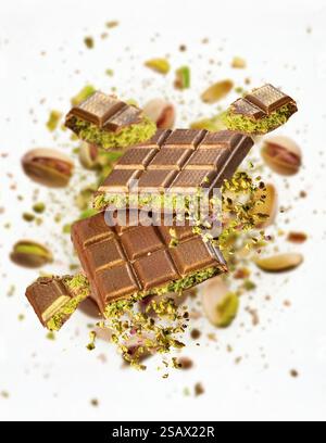 Milk chocolate bars with pistachio cream filling exploding on white background Stock Photo