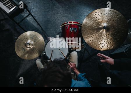 Overhead view of drummer playing drums and cymbals in a music studio Stock Photo
