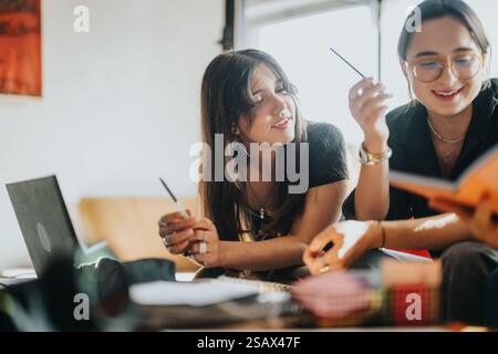Students collaborating on school assignments with laptops and books Stock Photo