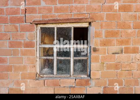 Old broken window in a brick house Stock Photo