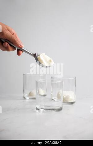 ice cream being scooped in three glasses for affogato coffee Stock Photo
