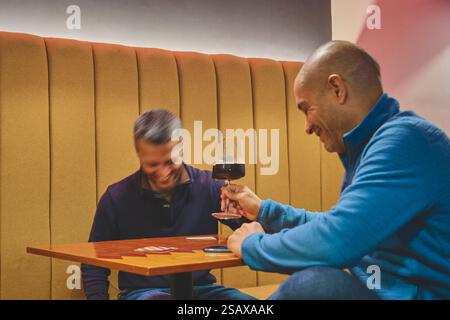 Two men enjoying craft beer at a cozy bar Stock Photo