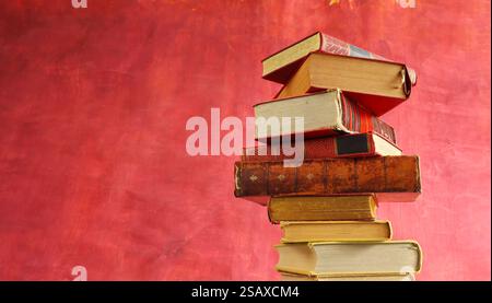 Row of red books on red grungy background, reading, learning, education knowledge is power or home office concept Stock Photo