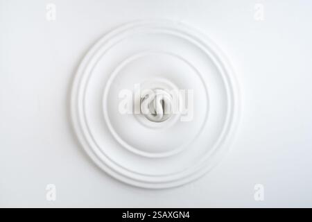 Bottom view of spiral energy saving bulb on white ceiling Stock Photo