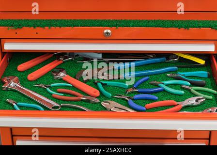 Assorted pliers wrench clamping tools displayed in open toolbox drawer. Stock Photo