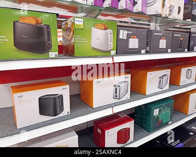 Appliance store shelf displaying various brands of toasters in colorful packaging boxes. Stock Photo