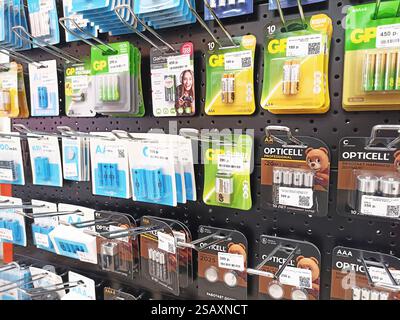 Assorted batteries displayed on store shelf with various brands and types. Stock Photo