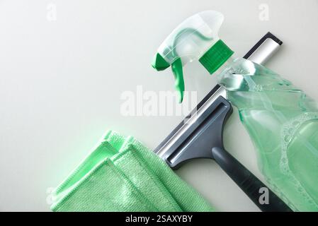 Window cleaner spatula, spray product and microfibre cloth isolated on white table. Top view. Stock Photo