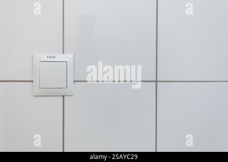 A clean white wall featuring a switch plate accentuates a minimalist and modern design Stock Photo