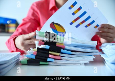 Accountant woman hands holding stacks files, business reports and stock charts. Financial and paperwork concept Stock Photo