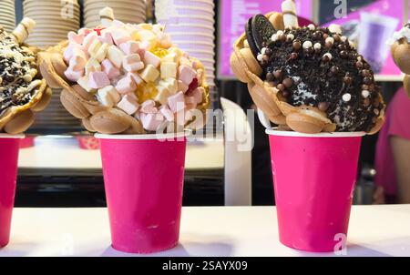 Bubble Waffle cone: Close-up of Assorted Ice Cream Cones with different flavors of ice creams, cookies and sprinkles in a Display in an ice cream Stock Photo