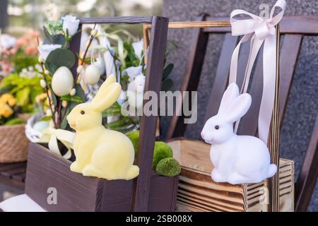 Easter basket with eggs decorated with wreath made of carnations, buxus and catkins.  Stock Photo