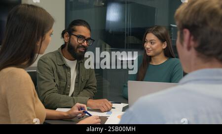 Business team multi ethnic women men group co-workers colleagues young creative managers sit at office conference table share ideas discuss startup Stock Photo