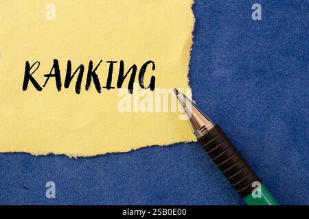 Ranking message written on ripped torn yellow paper on blue background. Conceptual ranking symbol. Copy space. Stock Photo