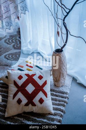 Two decorative pillows lie on the floor next to a light decorative vase. Stock Photo