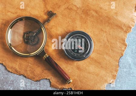 Compass, magnifying glass and key on background grunge paper Stock Photo