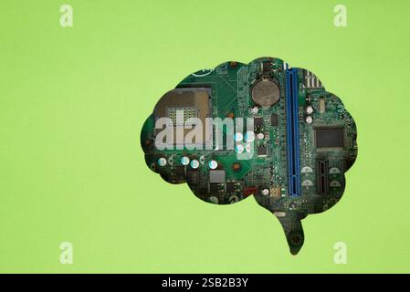 Green sheet of paper with brain-shaped hole revealing a computer motherboard. Technology concept. Stock Photo