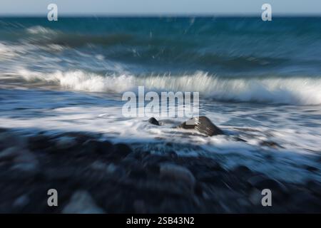 waves crashing onto a rocky shore, motion blur and zoom effect Stock Photo