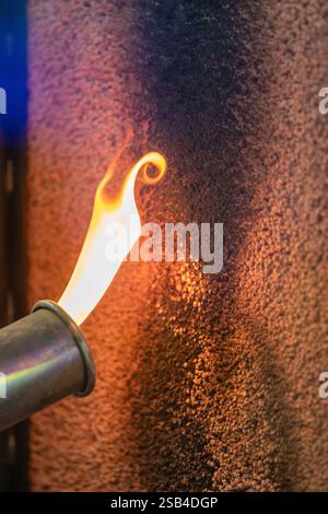 Flame testing fire retardant material, highlighting fire safety, heat resistance, and material testing in a controlled environment. Stock Photo