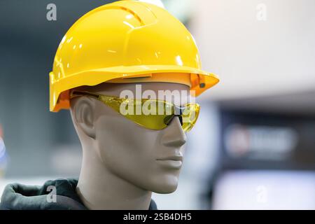Personal protective equipment (PPE) mannequin equipped with essential safety gear, including a yellow hard hat and tinted safety glasses. Ideal for showcasing construction or industrial safety equipment. Stock Photo