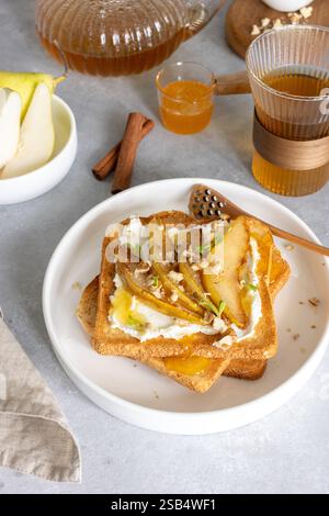 Breakfast with cream cheese toasts and caramelized pears, honey and walnuts Stock Photo