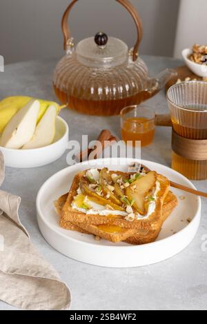 Breakfast with cream cheese toasts and caramelized pears, honey and walnuts Stock Photo