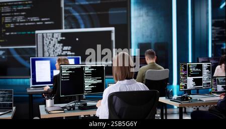 Multiracial Team of Software Engineers Developing Code on Desktop Computers Stock Photo