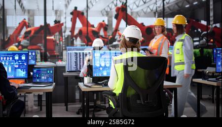Diverse team uses Scada automation software on desktop at factory. Stock Photo