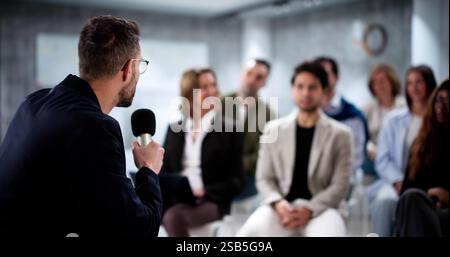 Professional Speaker Captivates Diverse Audience with Inspiring Business Presentation. Stock Photo