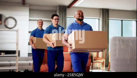 Professional Movers Smiling While Holding Boxes in Residential Room Stock Photo
