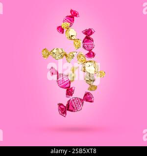 Candies in bright wrappers falling on pink background Stock Photo