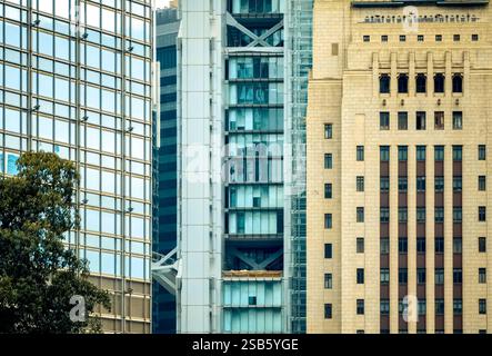 Close-up view of Hong Kong buildings showcasing architectural details.  Modern glass towers contrast with older, tan stone structures.  A blend of old Stock Photo