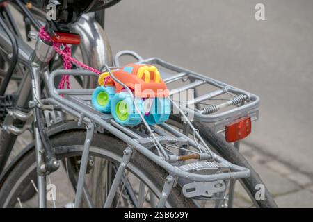 a bicycle with a children's toy - a colorful car - attached to its trunk. Stock Photo