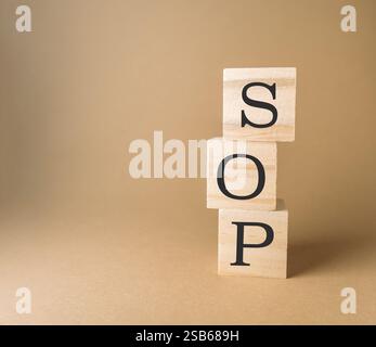 Stack of wooden blocks with the letters SOP on top. The blocks are arranged in a way that they spell out the word "SOP". Concept of playfulness and cr Stock Photo