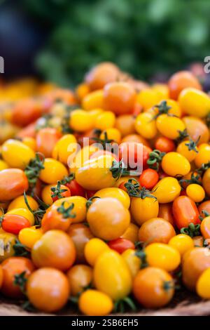 Pile of yellow and red cherry tomatoes on display at a farmers market Stock Photo