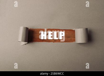 Torn piece of paper with the word HELP written on it Stock Photo