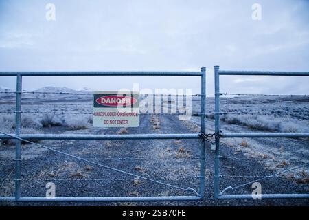 A locked gate marks the entrance to the Sierra Army Depot near Herlong, CA, warning of dangers from unexploded ordnance Stock Photo