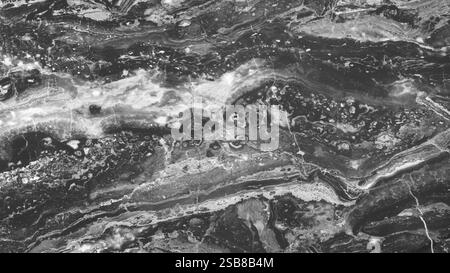 background of a stone wall with a gray and white pattern. The wall looks like it is made of marble and has a rough texture. The photo creates a sense Stock Photo