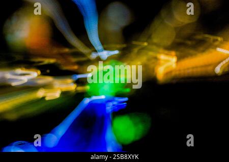 Long exposure Bokeh effect of multicolored lights, including green, blue, and orange, out of focus., Stock Photo