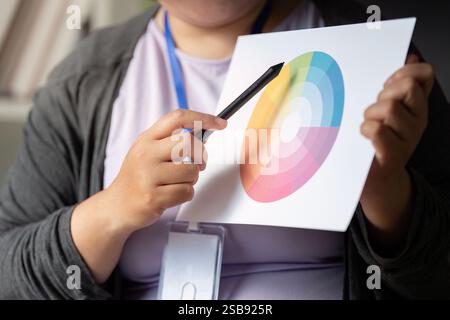 Graphic designer analyzing a color wheel for creative design projects Stock Photo
