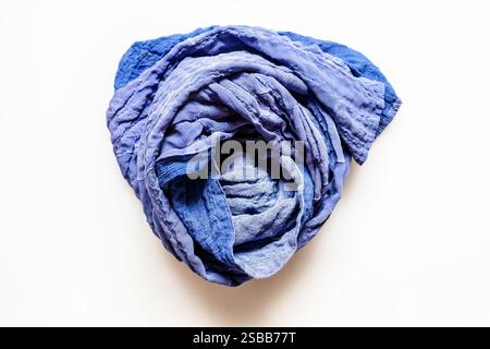 top view of rolled blue patchwork scarf sewn from stitched silk fabrics on white background Stock Photo